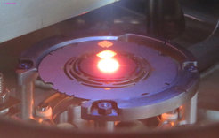 SrTiO₃ crystal at 1300 °C in the deposition chamber. Each reflection in the double pane window is weaker than its lower neighbor by a factor of 600.