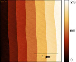 Atomic Force Microscopy (AFM) image of a SrTiO₃ surface prepared by high-temperature annealing. The terraces are covered by a uniform surface reconstruction as an ideal template for subsequent epitaxy.