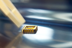 Für die Bauelemente wird Graphen mit einem Klebeband von einem Graphitkristall abgelöst, auf einem Träger mit Elektroden versehen und in einem Chipträger integriert.