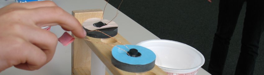 BOGY & BORS A hand holds a copper wire with a supermagnet that has been cooled so that it levitates in the magnetic field.
